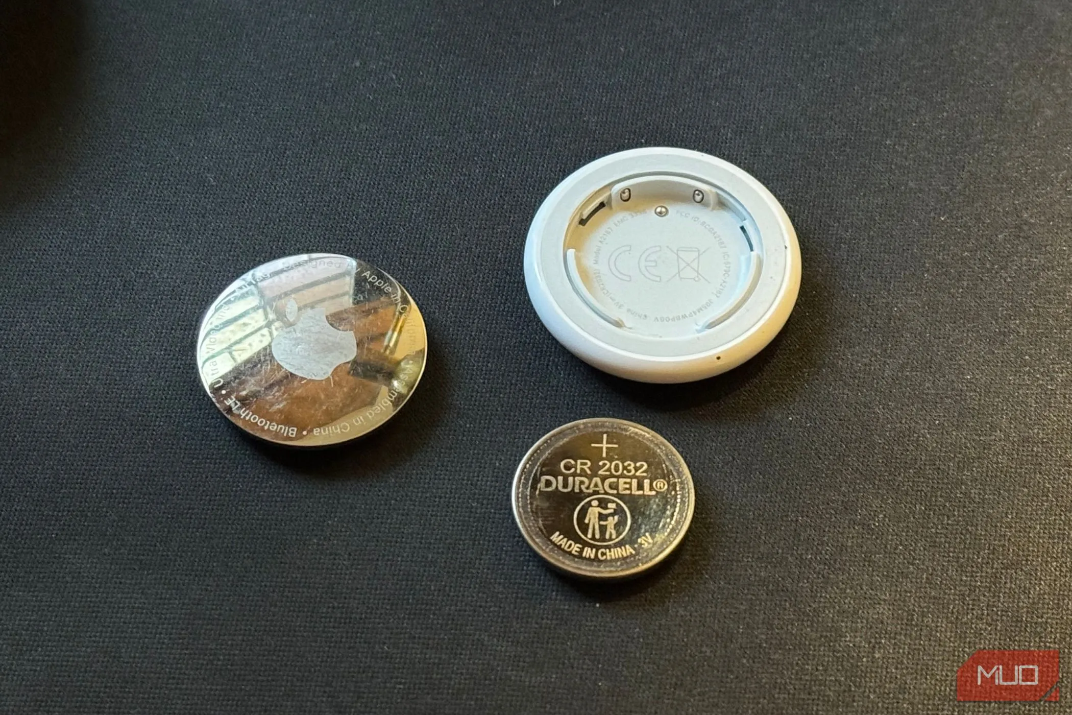 AirTag tháo rời và pin CR2032 trên nền đen