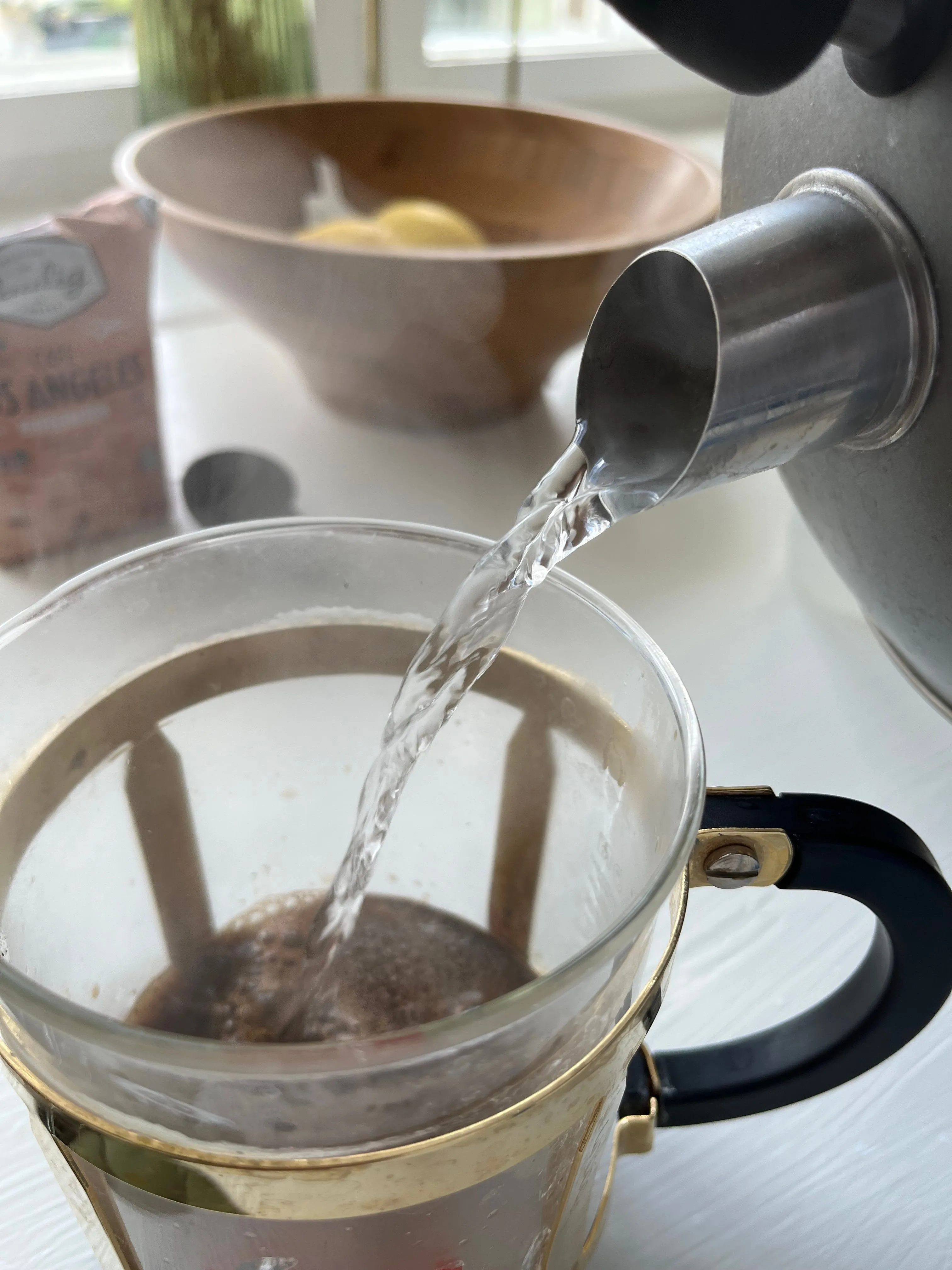 Ảnh chụp nước được rót từ ấm vào máy pha cà phê, ghi lại chi tiết quá trình pha chế.