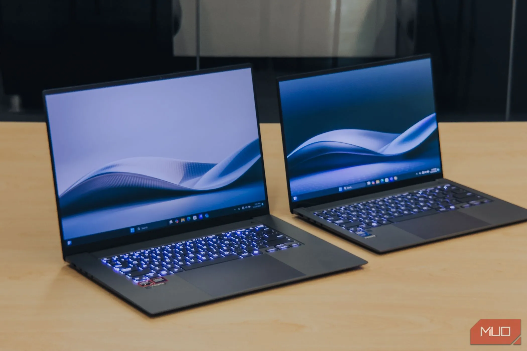ASUS Zenbook S 16 đặt cạnh Zenbook S14 trên bàn gỗ