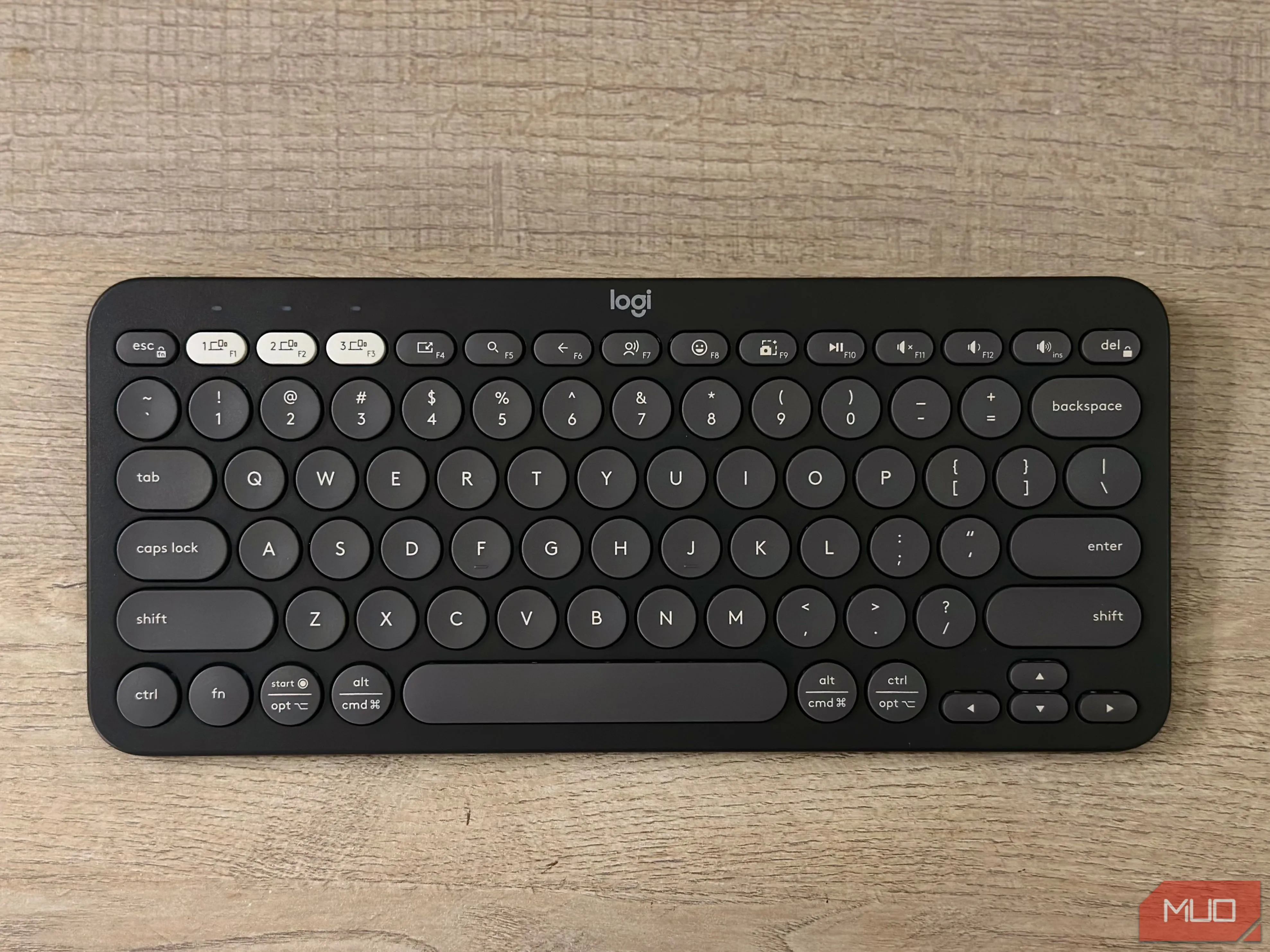 Bàn phím Logitech Pebble Keys 2 K380s màu đen trên mặt bàn, thể hiện sự gọn gàng và tiện lợi cho việc gõ phím trên iPad.