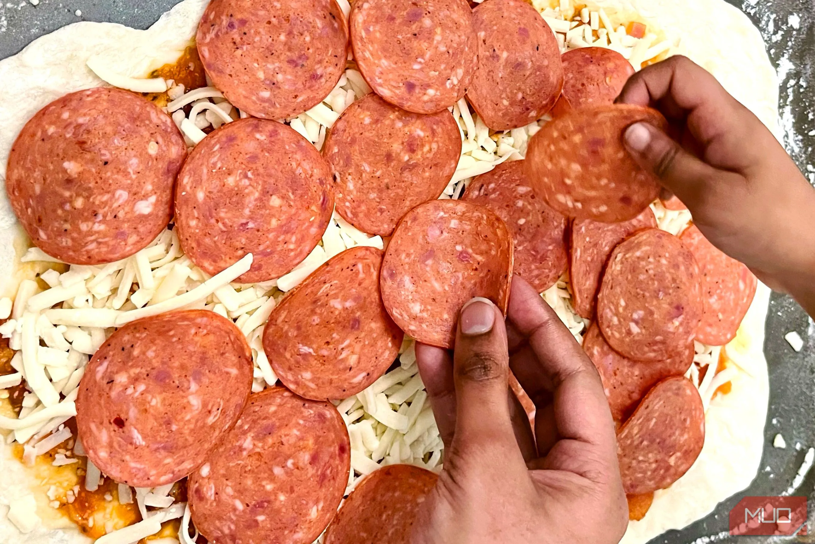 Bàn tay đang làm bánh pizza, tạo cảm giác chân thực và ấm cúng