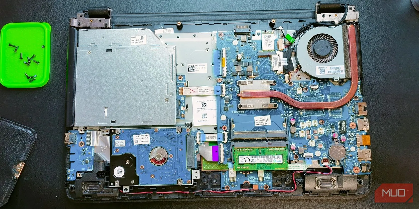 Bên trong một chiếc laptop được mở ra, cho thấy các linh kiện phần cứng như quạt tản nhiệt, bo mạch chủ và ổ cứng, minh họa cho việc vệ sinh hoặc thay thế linh kiện bên trong
