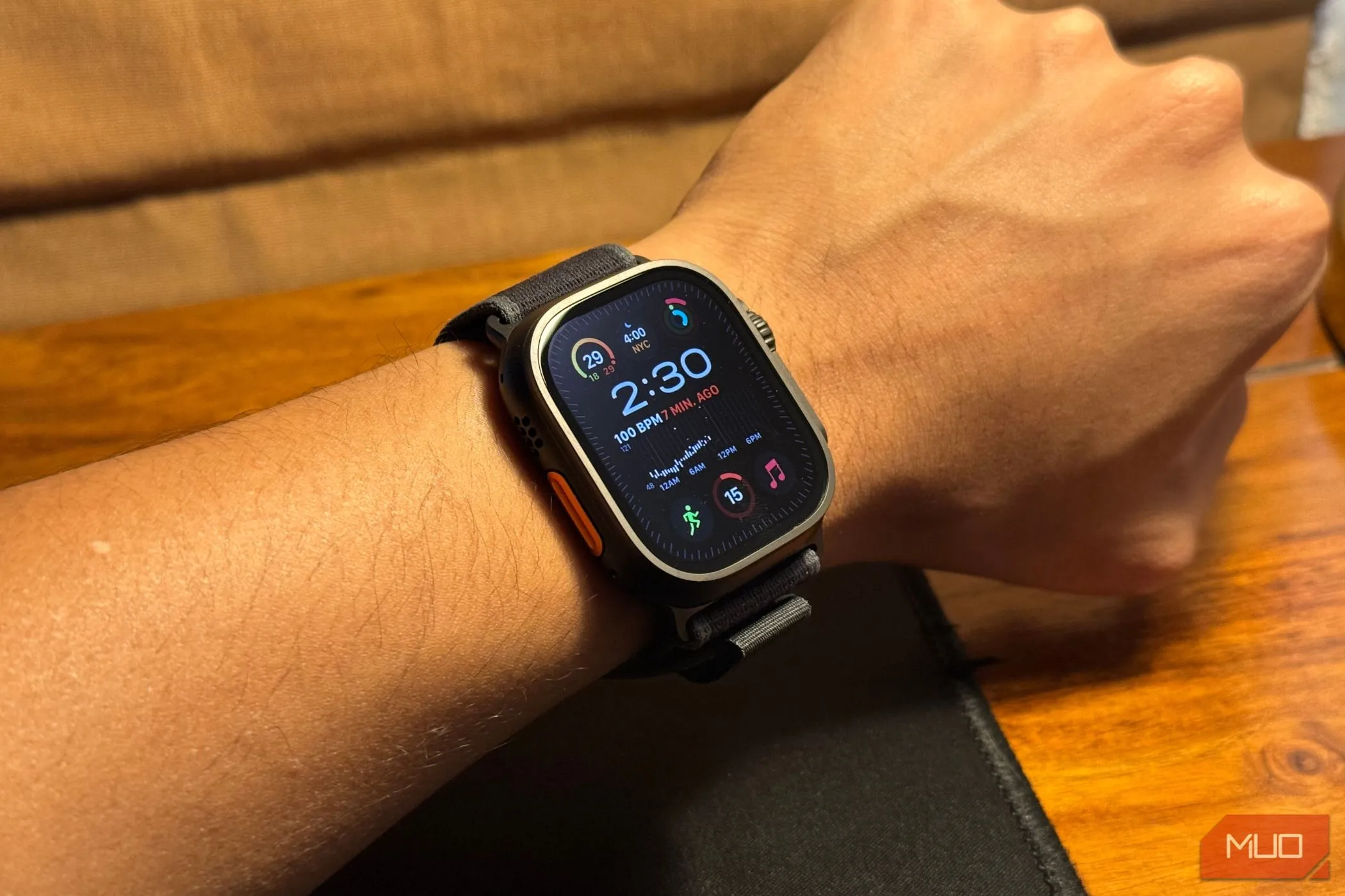 Cận cảnh cổ tay đeo Apple Watch Ultra 2 phiên bản titan đen, tôn lên thiết kế bền bỉ của đồng hồ.