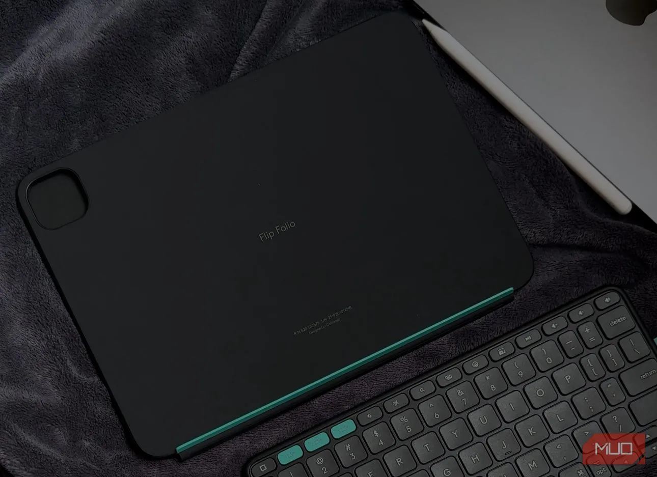 Case Logitech Flip Folio được đặt trên chăn cạnh iPad, thể hiện sự linh hoạt sử dụng trong mọi tư thế