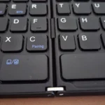 Chi tiết bản lề trên bàn phím Bluetooth gập, cho thấy thiết kế gấp gọn để tiện di chuyển