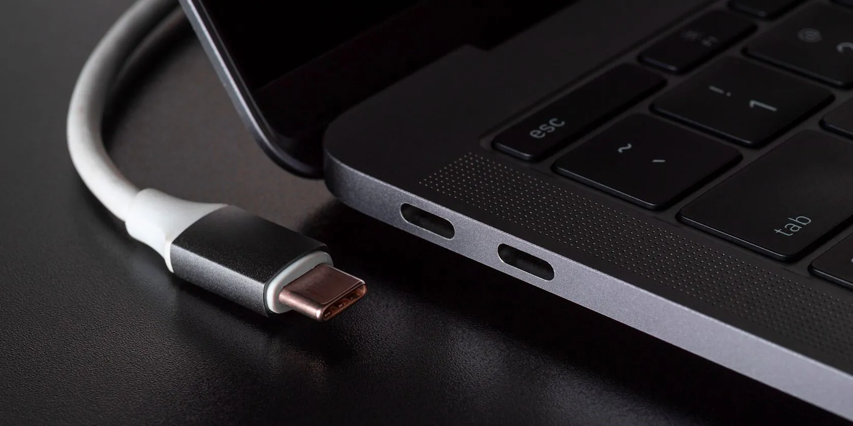 Cổng kết nối USB-C trên laptop với cáp sạc được cắm vào, tượng trưng cho việc kết nối nguồn điện để sạc nhanh.