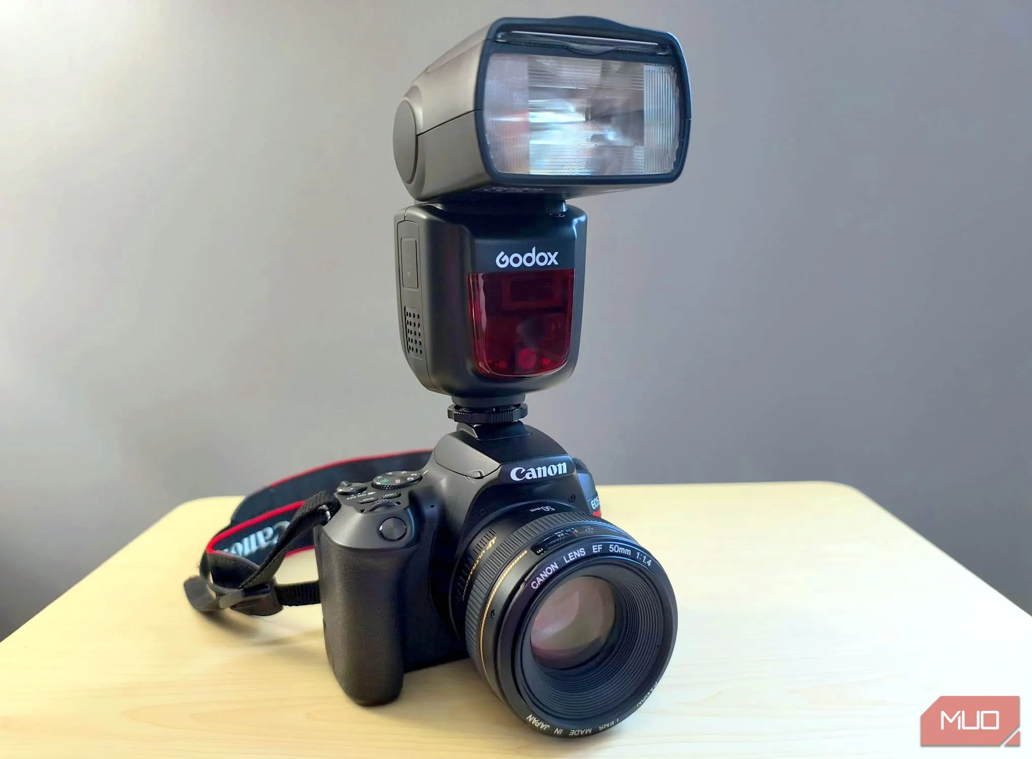 Đèn flash Godox V860II gắn trên máy ảnh chuyên nghiệp màu đen, thể hiện khả năng linh hoạt trong nhiếp ảnh