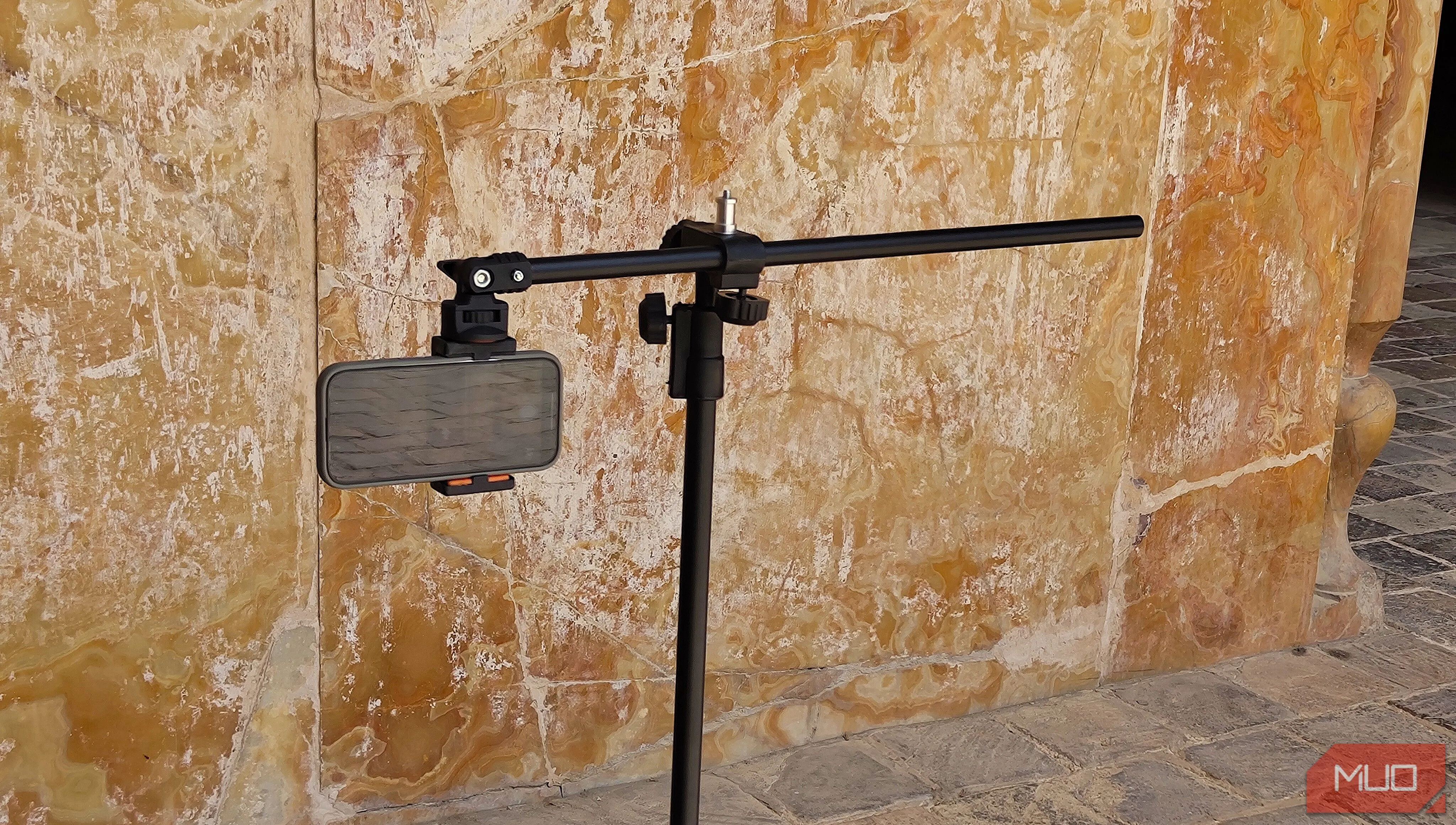 Điện thoại gắn trên chân máy tripod hướng thẳng vào một bức tường
