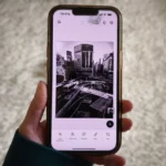 Điện thoại iPhone hiển thị giao diện ứng dụng Adobe Photoshop Mobile với các công cụ chỉnh sửa ảnh