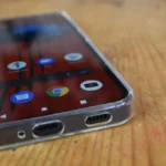 Điện thoại Nothing Phone 1 đang được sạc trong ốp lưng trong suốt, minh họa tác động của nhiệt độ và ánh sáng đến vật liệu ốp.