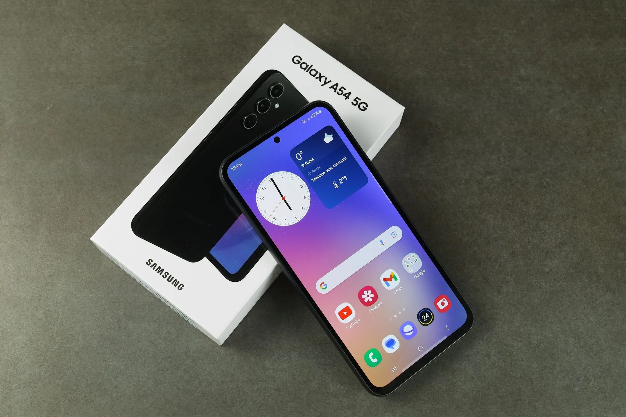 Điện thoại Samsung Galaxy A54 5G cùng hộp đựng, tượng trưng cho việc mua sắm và nâng cấp thiết bị di động định kỳ.