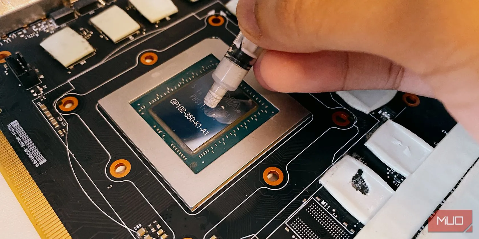 Hình ảnh minh họa quá trình thoa keo tản nhiệt (thermal paste) lên bề mặt chip GPU, giúp tối ưu khả năng dẫn nhiệt từ chip ra bộ tản nhiệt và giảm nhiệt độ hoạt động của laptop