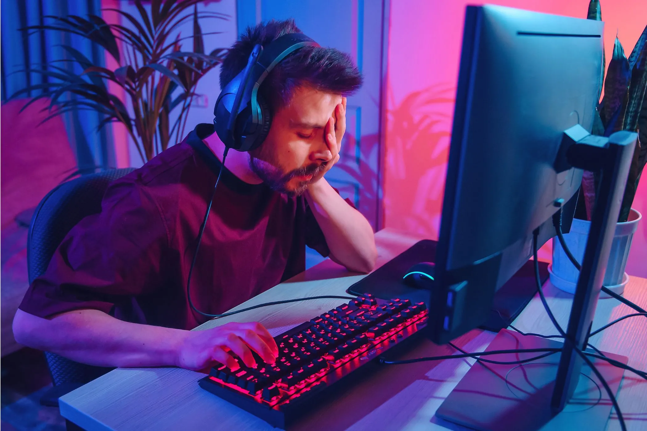 Hình ảnh một người dùng máy tính đang thất vọng, che mặt, thể hiện sự khó chịu khi PC bị soft-brick do cài đặt hệ điều hành không tương thích.