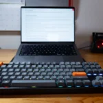 Keychron K8 Max đặt trên bàn làm việc trước MacBook, thể hiện sự chắc chắn