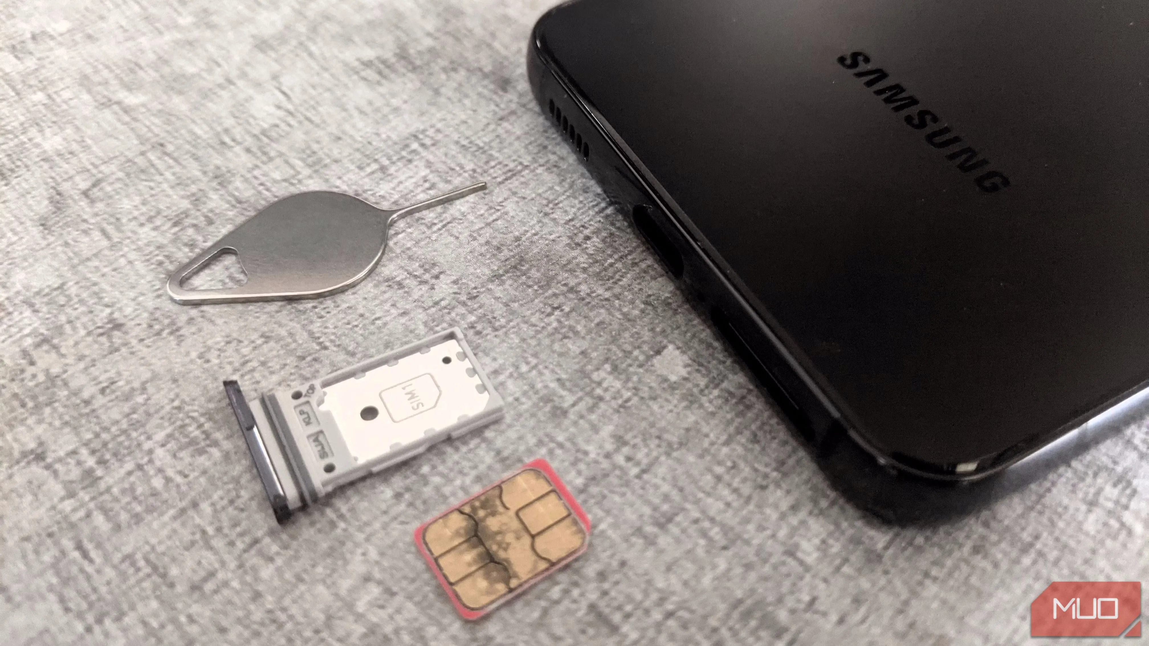 Khay SIM điện thoại Samsung và công cụ tháo SIM, biểu thị nguy cơ tấn công SIM swapping qua số điện thoại.