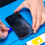 Kỹ thuật viên đang cẩn thận cạy mở smartphone để sửa chữa bên trong