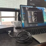 Laptop MacBook kết nối với màn hình ngoài thông qua hub USB-C, minh họa việc sử dụng nhiều thiết bị ngoại vi cùng lúc gây hao pin