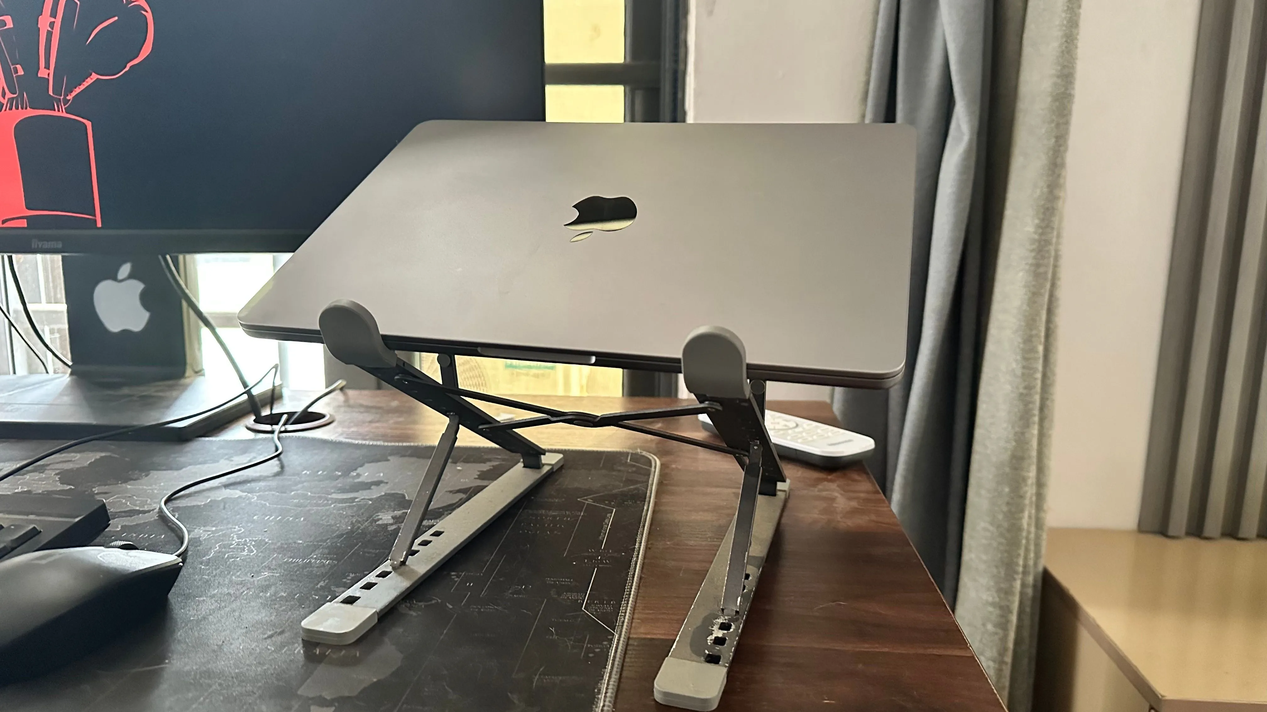 MacBook đặt trên đế tản nhiệt bên cạnh màn hình rời, tối ưu luồng khí và giảm nhiệt độ giúp bảo vệ pin