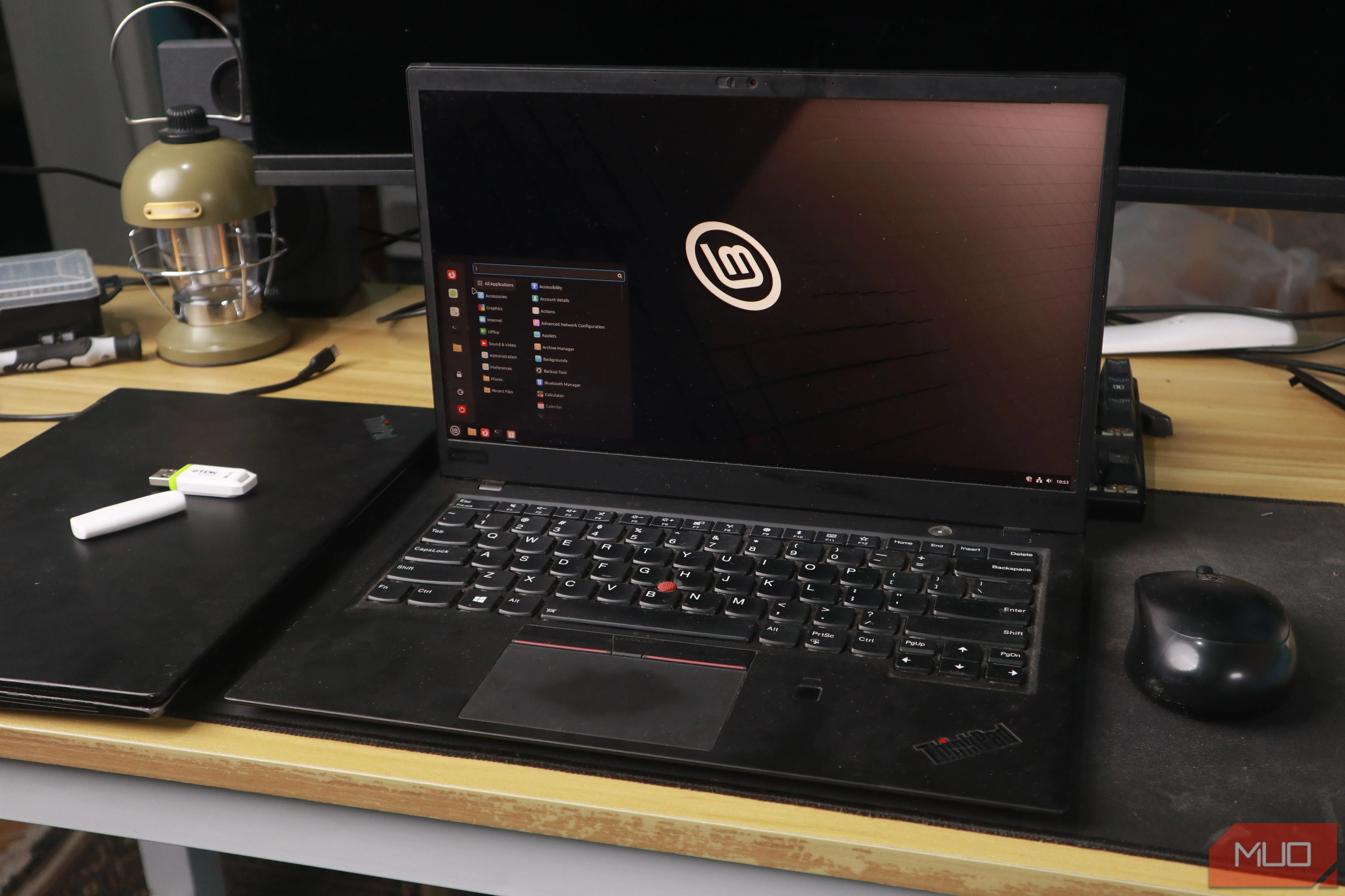 Màn hình desktop Linux Mint trên laptop ThinkPad cùng chuột và USB