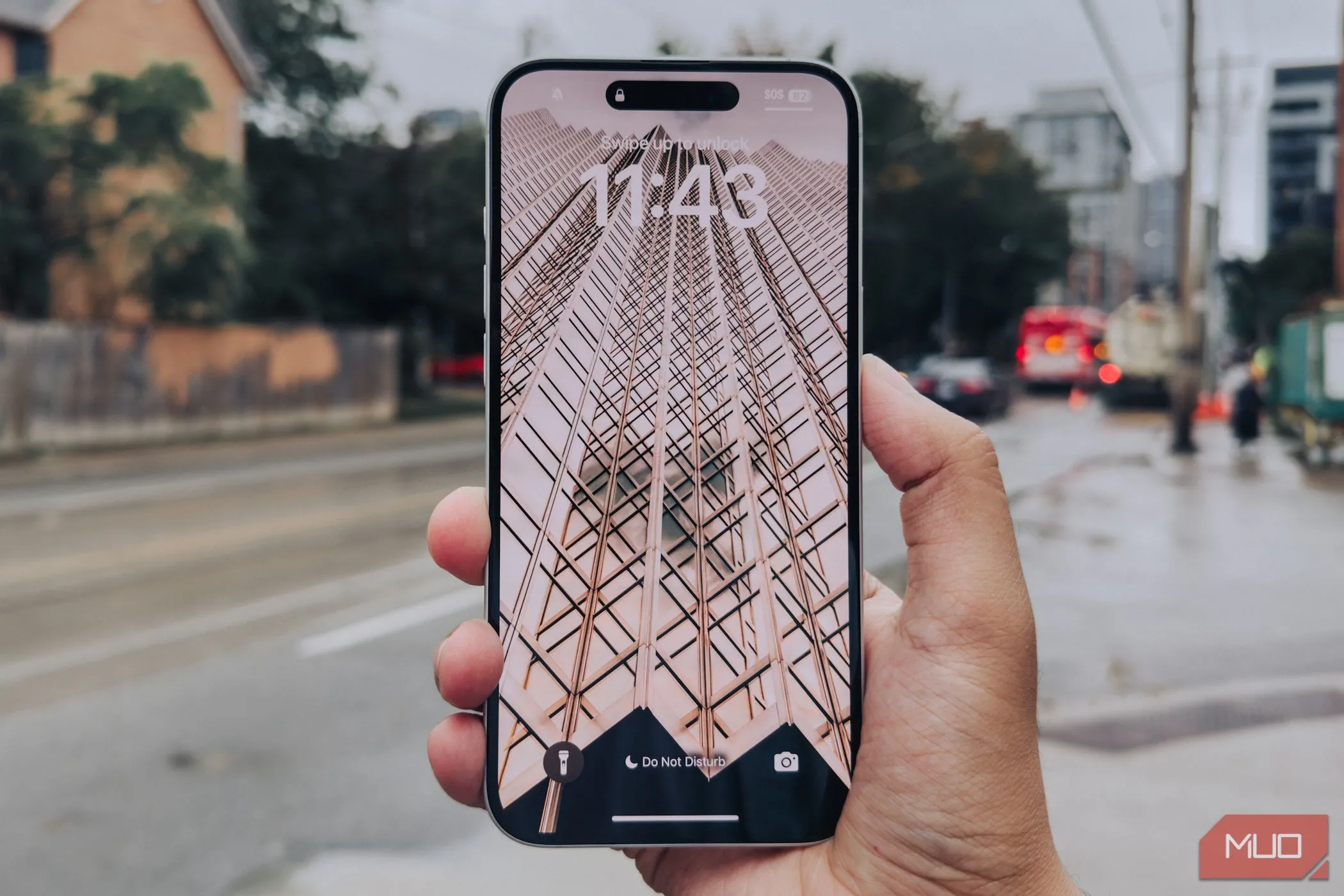 Màn hình viền mỏng của iPhone 16 Plus trong tay người dùng với nền thành phố, thể hiện xu hướng thiết kế smartphone hiện đại.