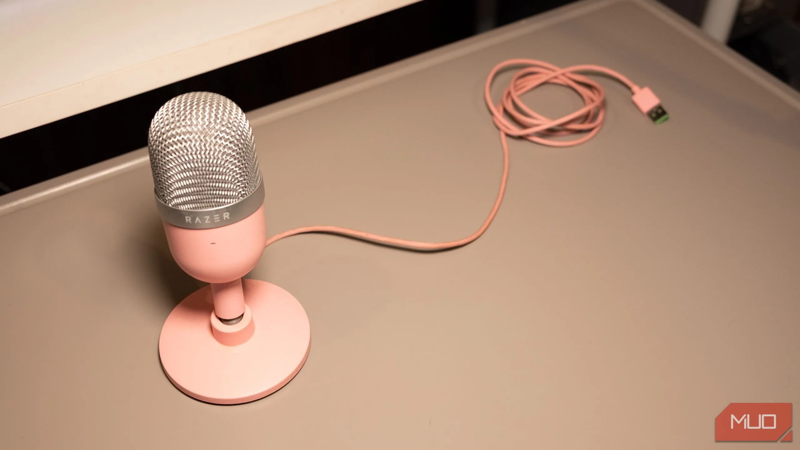 Micro USB condenser Razer Seiren Mini màu hồng đặt trên bàn làm việc
