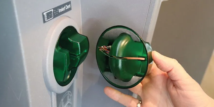Minh họa thiết bị skimmer giả mạo đặt chồng lên khe đọc thẻ thật tại cây ATM