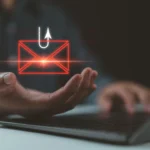 Móc câu và biểu tượng email bên cạnh máy tính xách tay, cảnh báo lừa đảo tuyển dụng trực tuyến