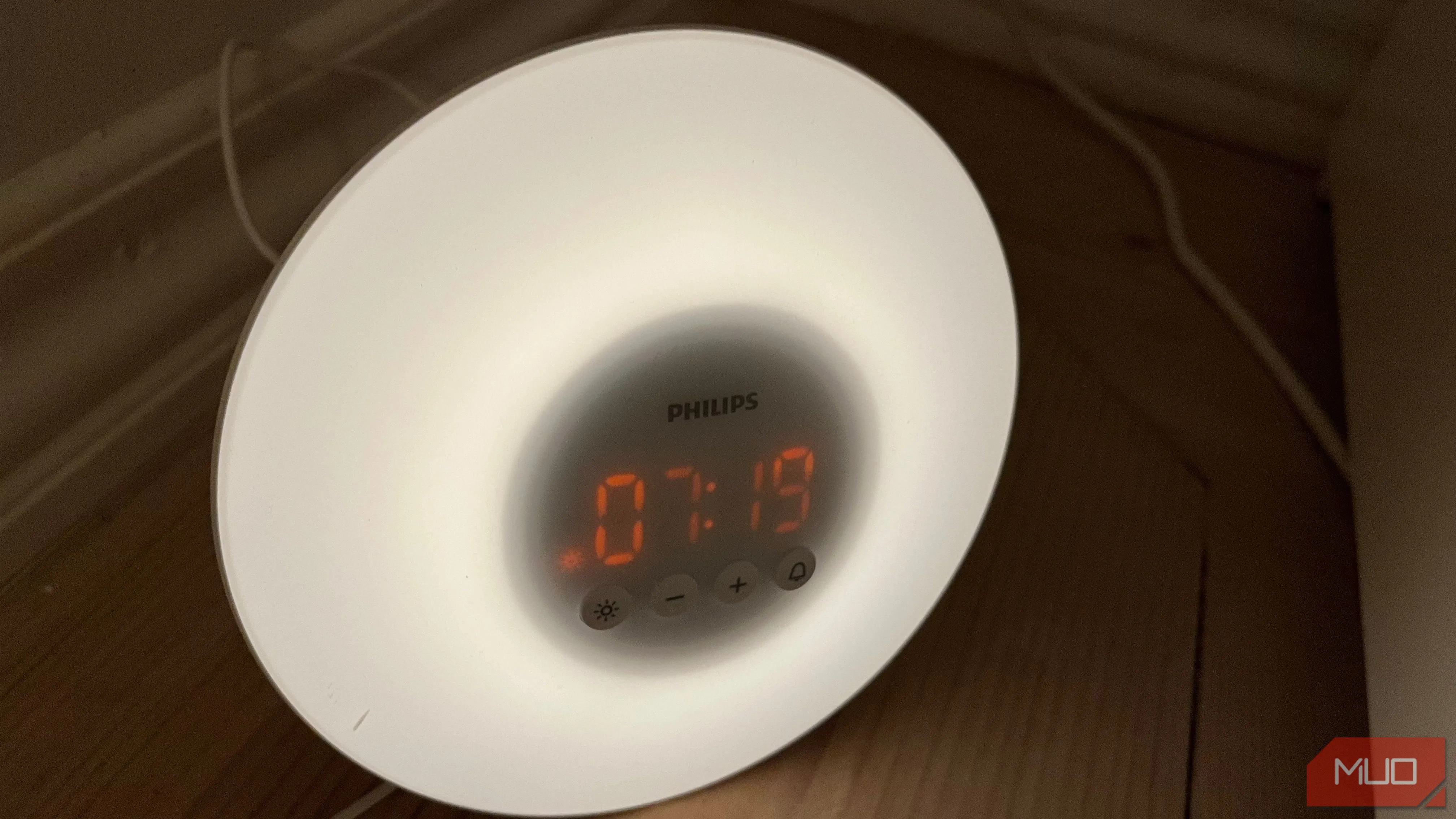 Một chiếc đồng hồ báo thức bình minh với ánh sáng dịu nhẹ đặt trên sàn, minh họa thiết bị hỗ trợ giấc ngủ tự nhiên.