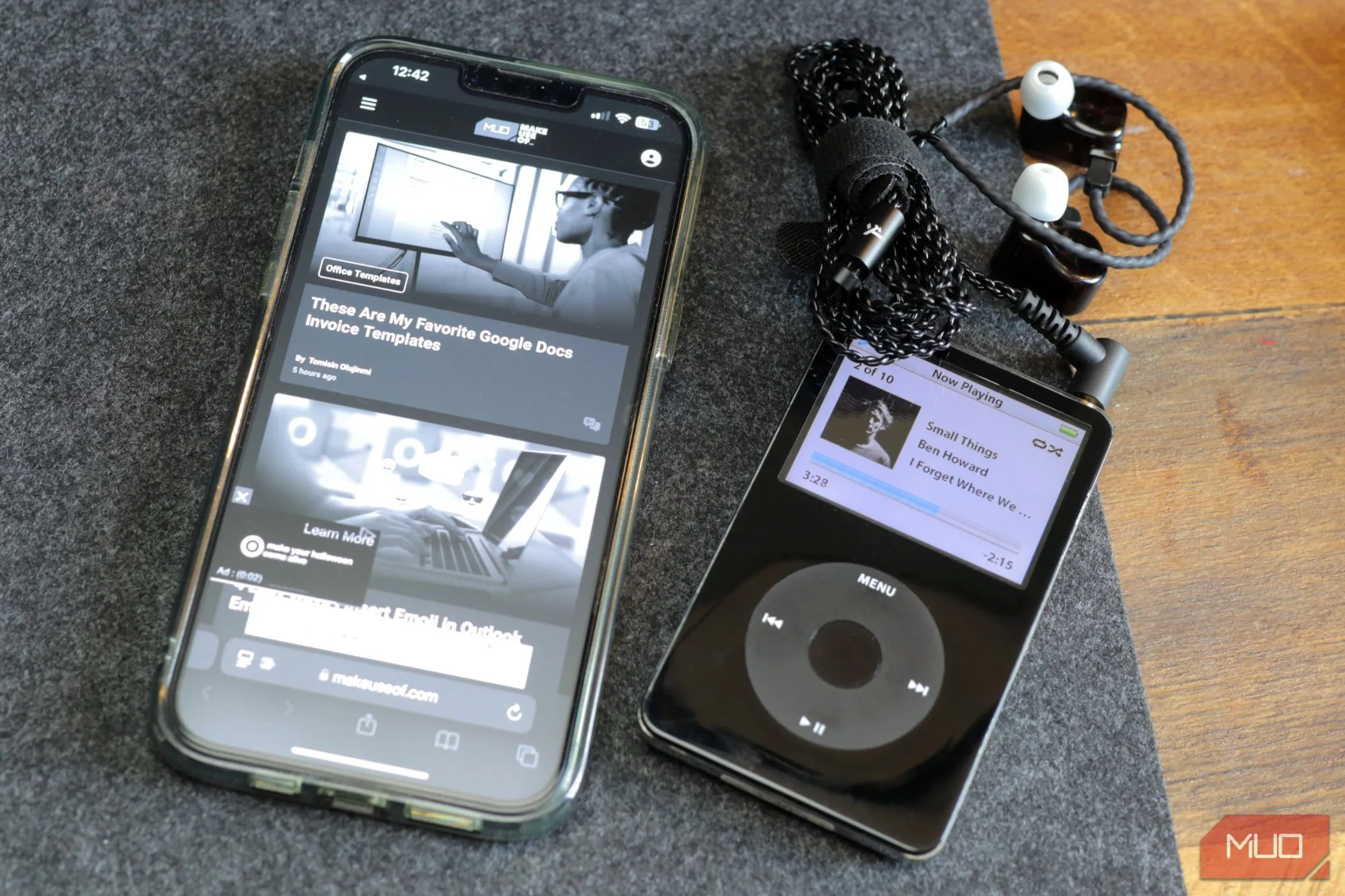 Một chiếc iPod cổ điển màu đen và iPhone 13 màu xám trên bàn làm việc, tượng trưng cho việc biến iPhone cũ thành máy nghe nhạc.