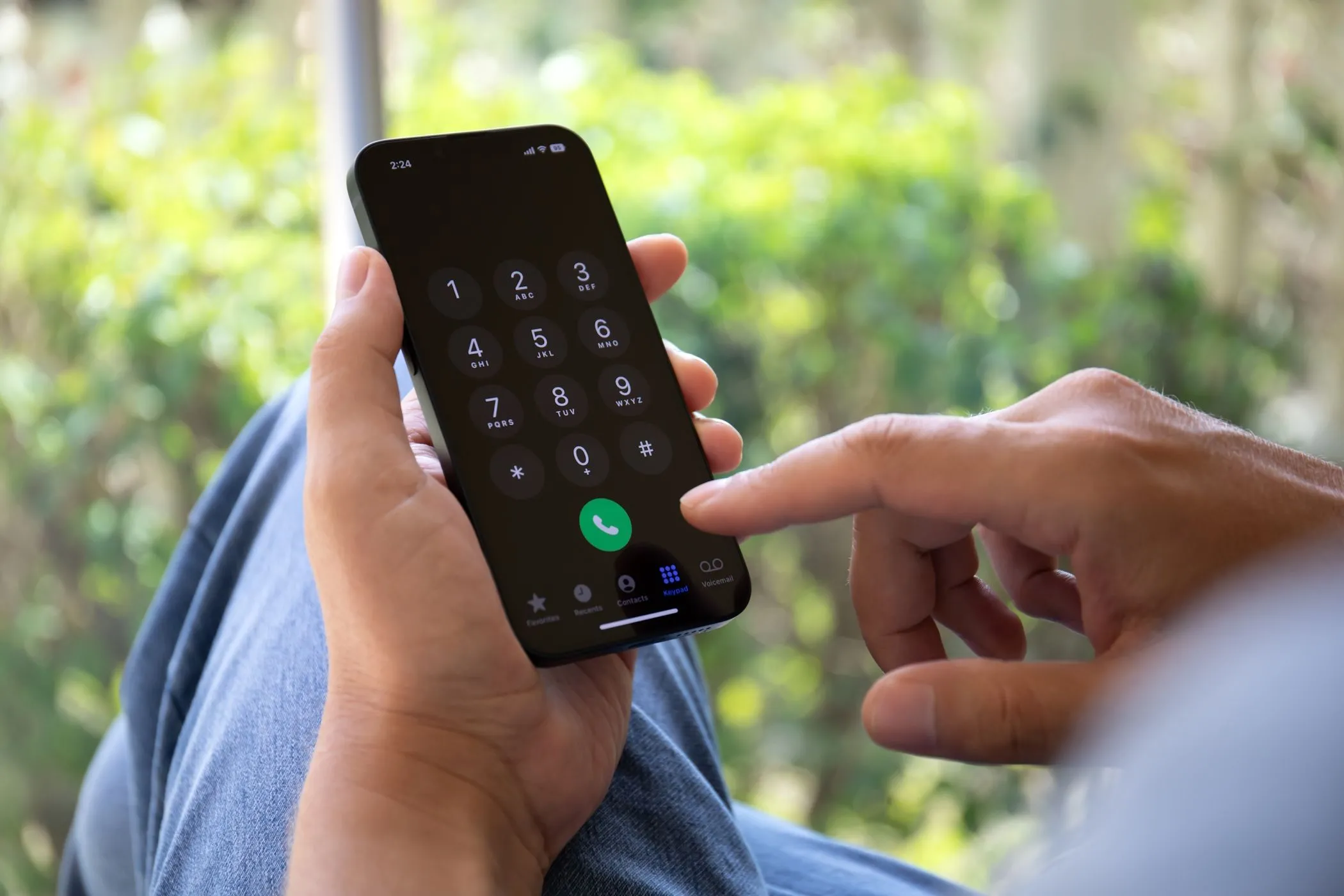 Một người đàn ông đang nhập số điện thoại trên iPhone, thể hiện sự phụ thuộc của 2FA SMS vào dịch vụ di động