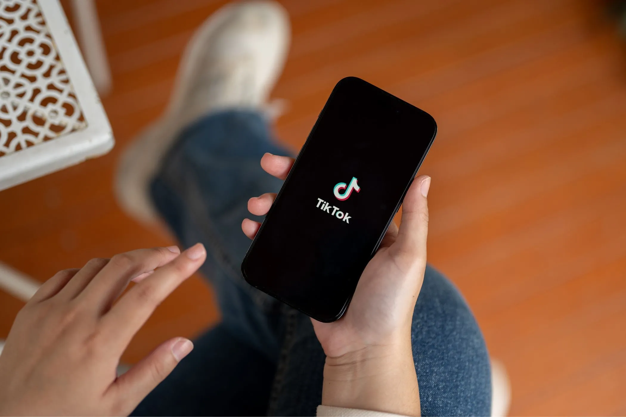Một người đang cầm điện thoại thông minh hiển thị ứng dụng TikTok, gợi ý về các rủi ro quyền riêng tư khi sử dụng ứng dụng.