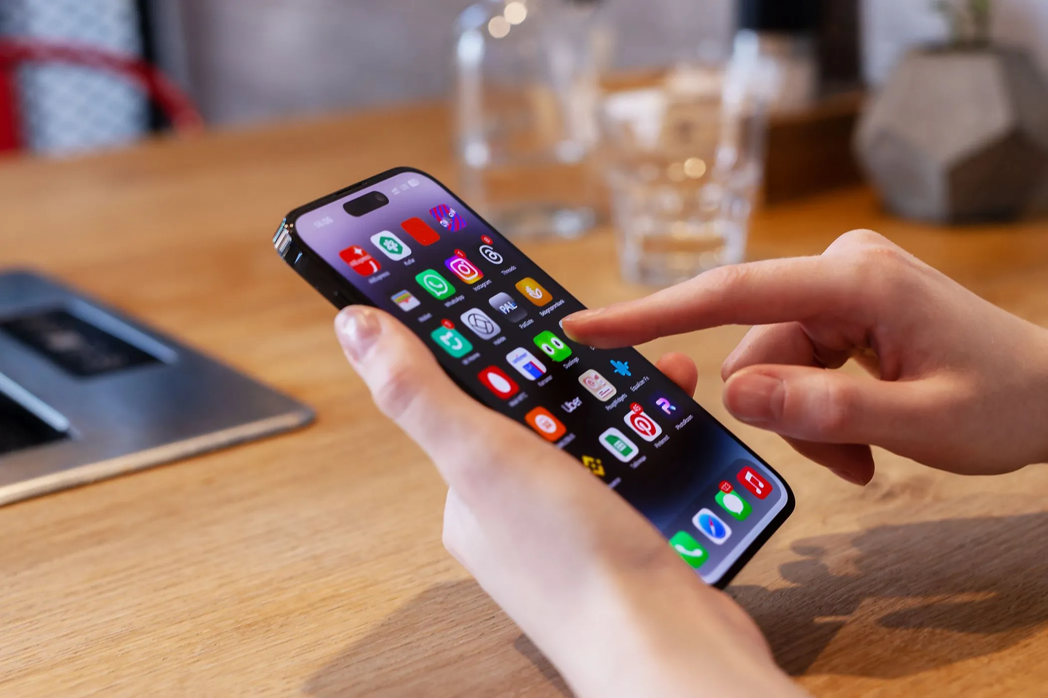 Một người dùng đang thao tác với điện thoại iPhone, minh họa trải nghiệm sử dụng thiếu tính năng liên kết nguồn.