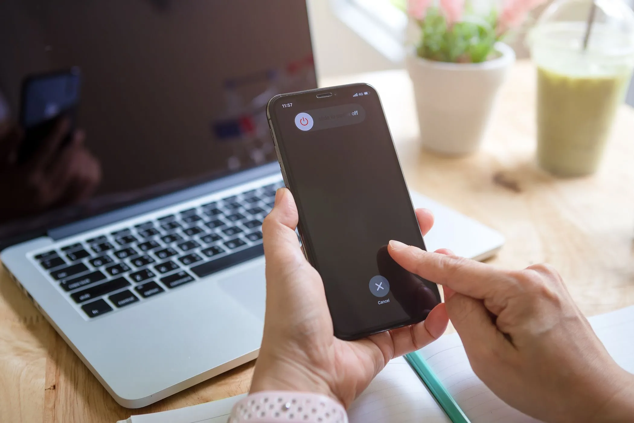 Một người phụ nữ đang thao tác tắt nguồn iPhone, bối cảnh liên quan đến lầm tưởng về việc sạc nhanh hơn khi tắt máy
