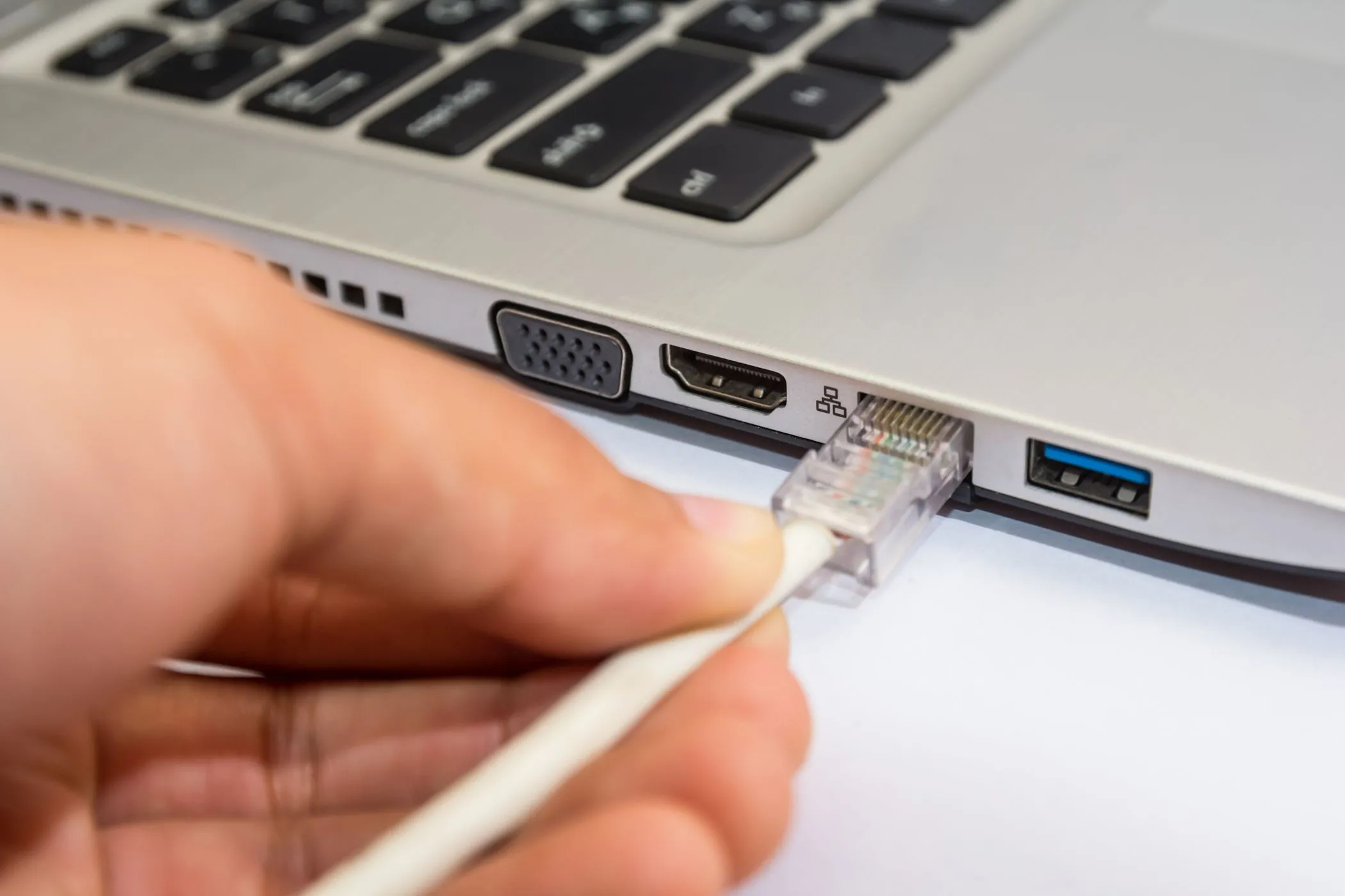 Người dùng đang cắm cáp mạng Ethernet vào máy tính xách tay Windows