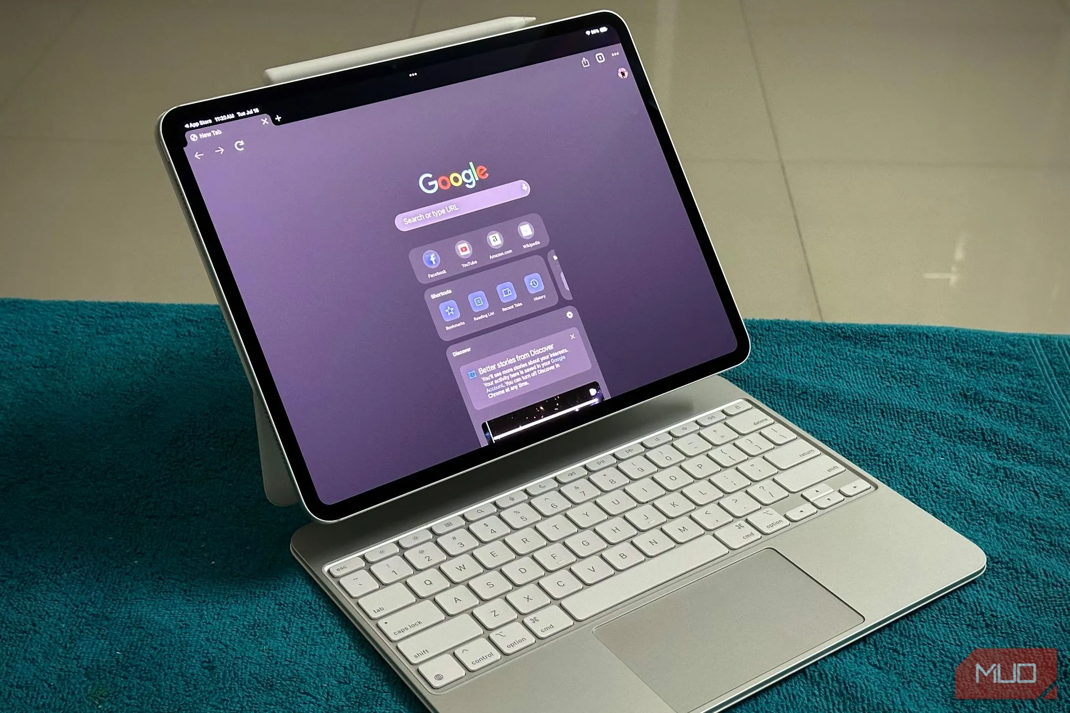 Người dùng đang gõ trên iPad Pro gắn bàn phím Magic Keyboard của Apple trong một không gian làm việc hiện đại