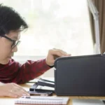 Người dùng đang kiểm tra máy in gặp lỗi trên bàn làm việc