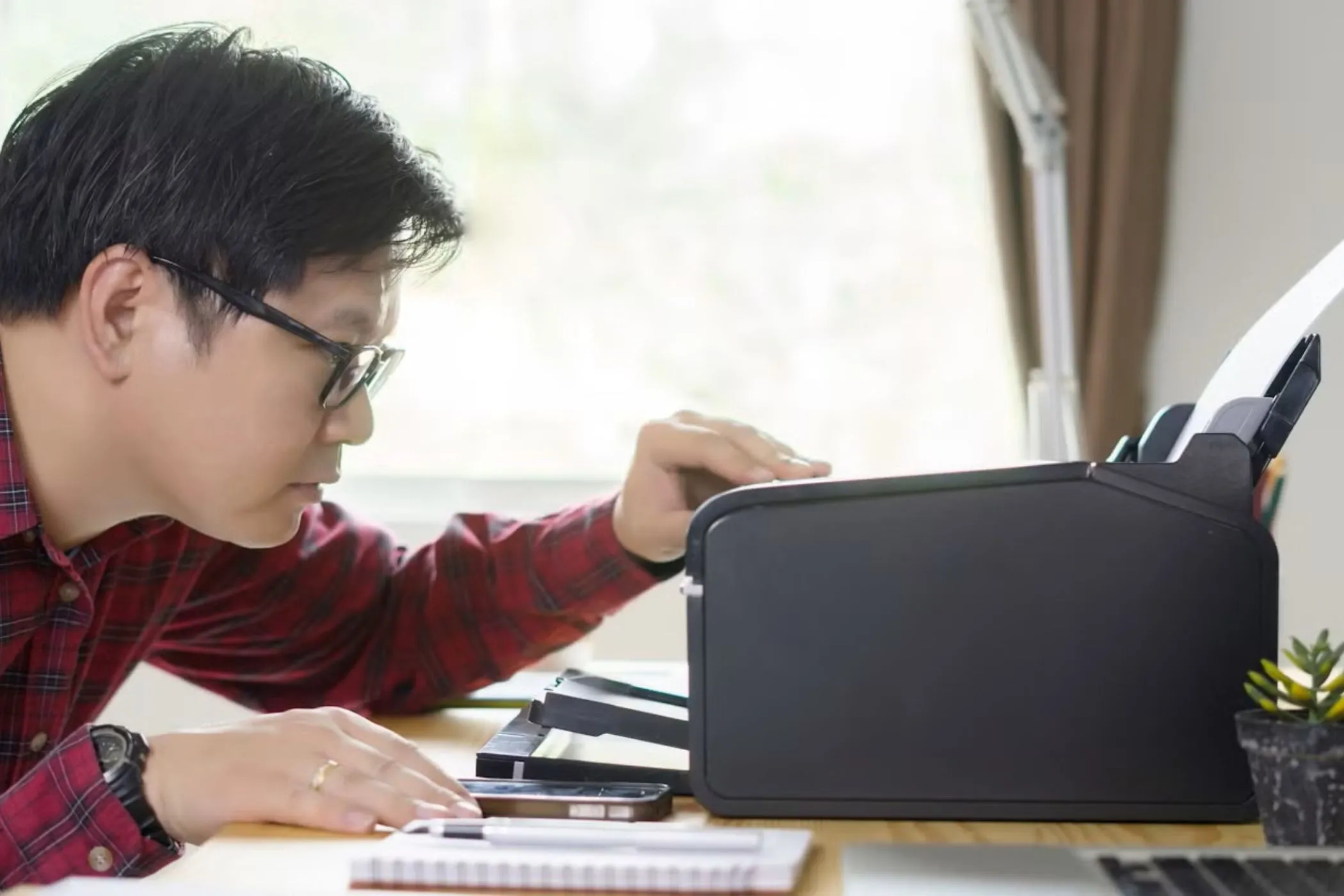 Người dùng đang kiểm tra máy in gặp lỗi trên bàn làm việc