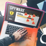 Người dùng đang quét phần mềm gián điệp trên laptop với các dấu hiệu cảnh báo