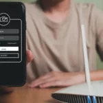 Người dùng kiểm tra cài đặt bảo mật Wi-Fi trên điện thoại cạnh router không dây