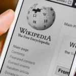 Người dùng mở ứng dụng Wikipedia trên điện thoại để tra cứu thông tin, minh họa vai trò của Wikipedia trong việc cung cấp kiến thức đáng tin cậy