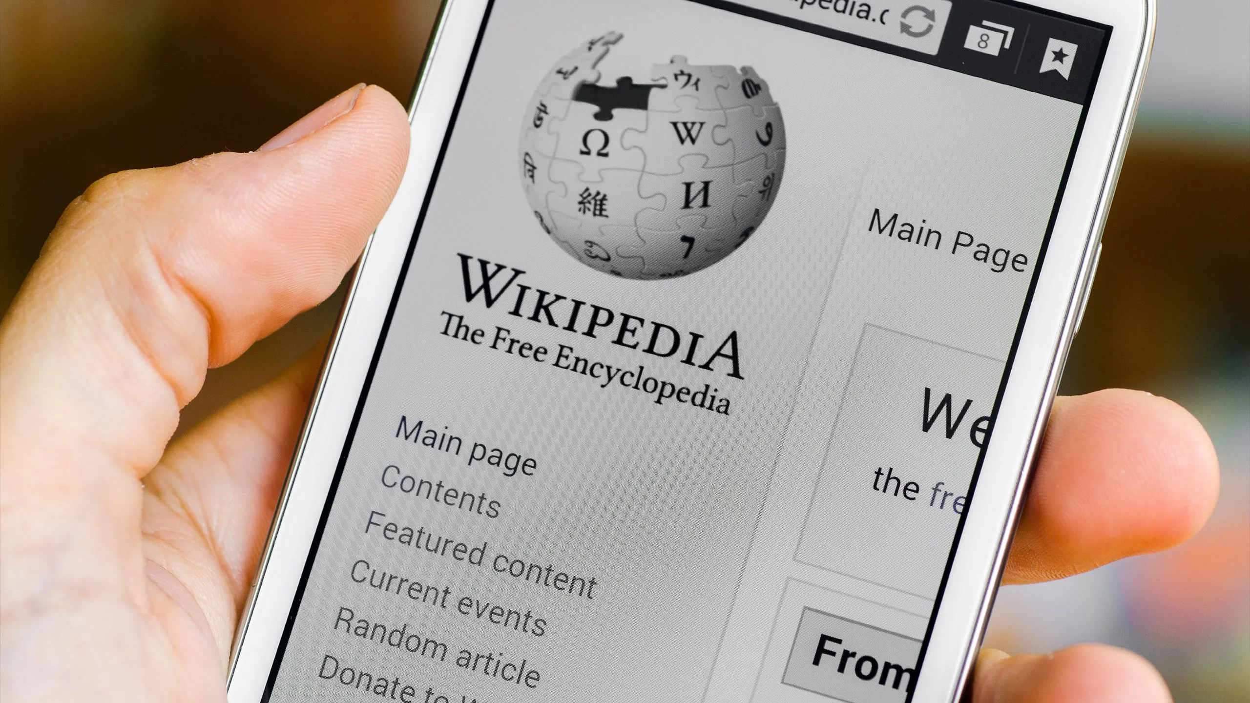 Người dùng mở ứng dụng Wikipedia trên điện thoại để tra cứu thông tin, minh họa vai trò của Wikipedia trong việc cung cấp kiến thức đáng tin cậy