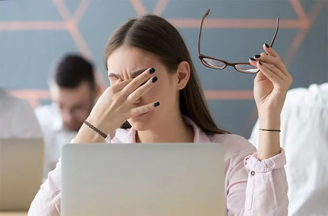 Người phụ nữ bị mỏi mắt do sử dụng thiết bị điện tử trong thời gian dài