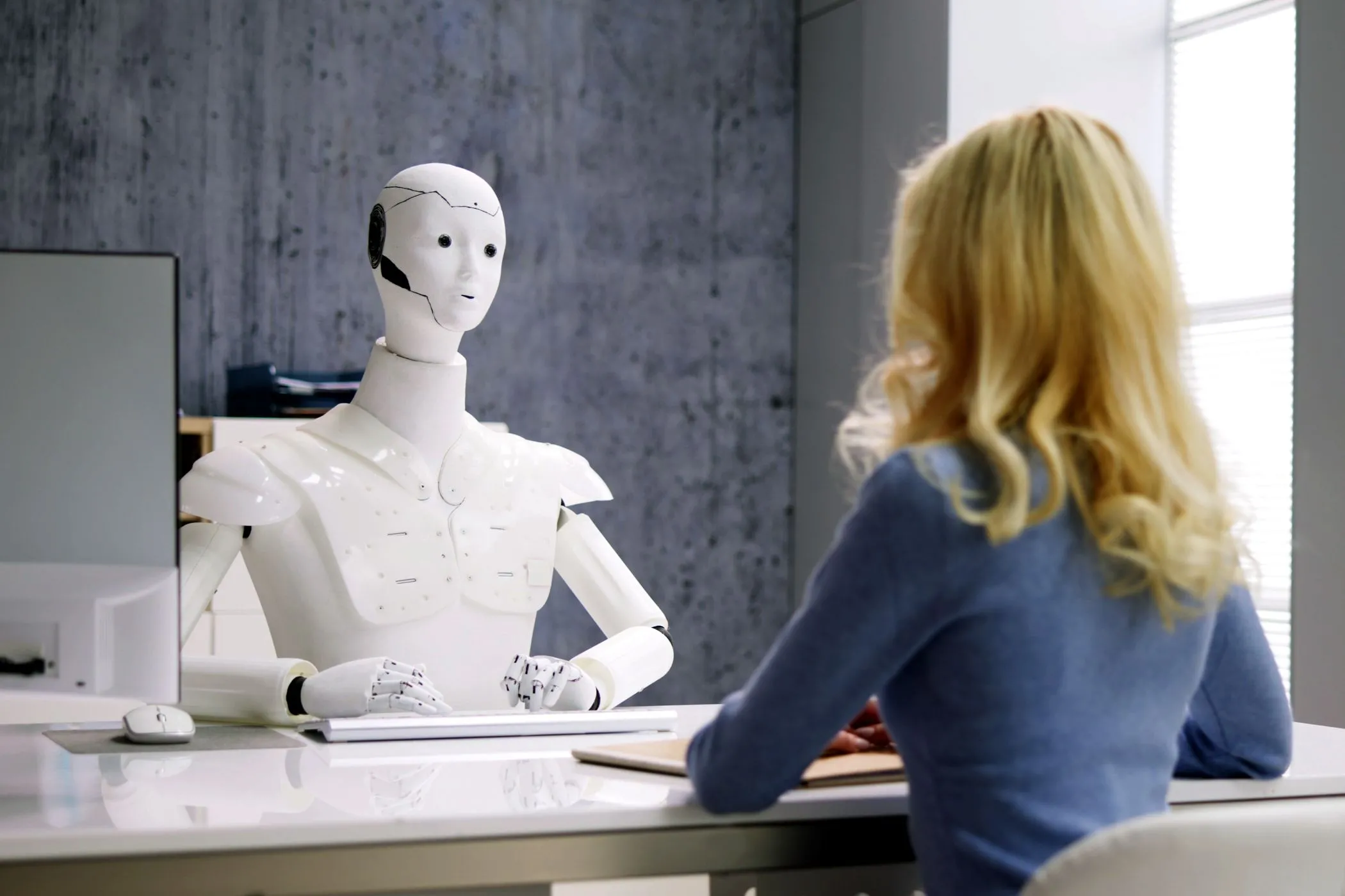 Người phụ nữ phỏng vấn robot AI, minh họa khả năng tương tác tự chủ của AI Agent trong môi trường chuyên nghiệp