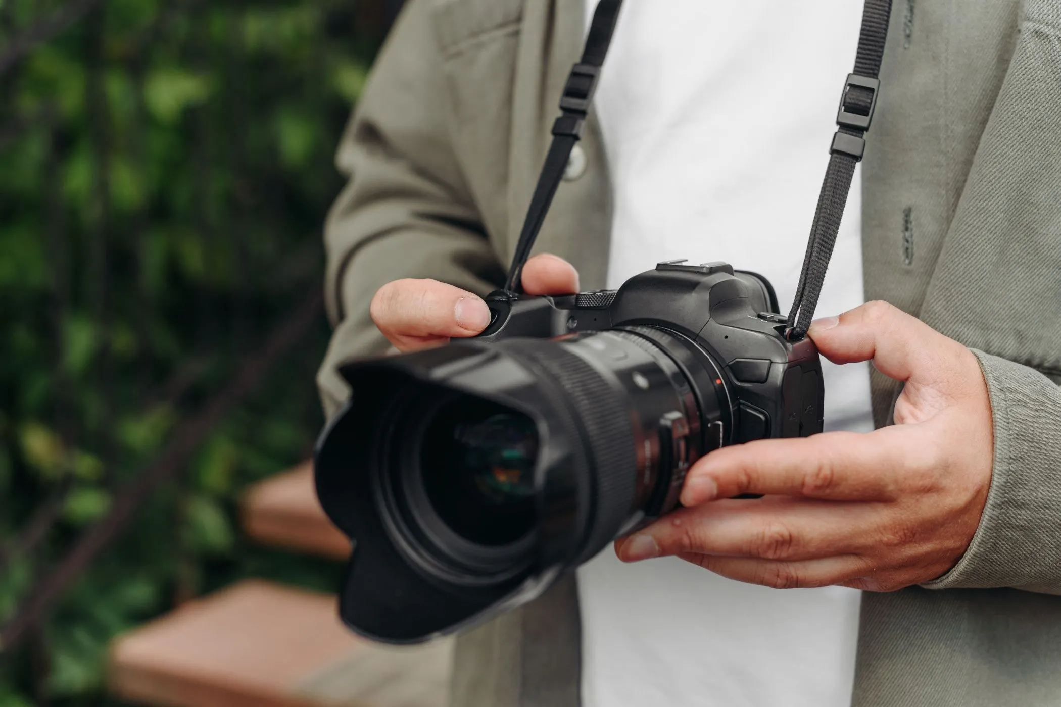 Nhiếp ảnh gia trẻ tuổi cầm máy ảnh DSLR với vẻ chuyên nghiệp, nhấn mạnh độ bền bỉ và sự phù hợp của thiết bị trong mọi điều kiện sử dụng