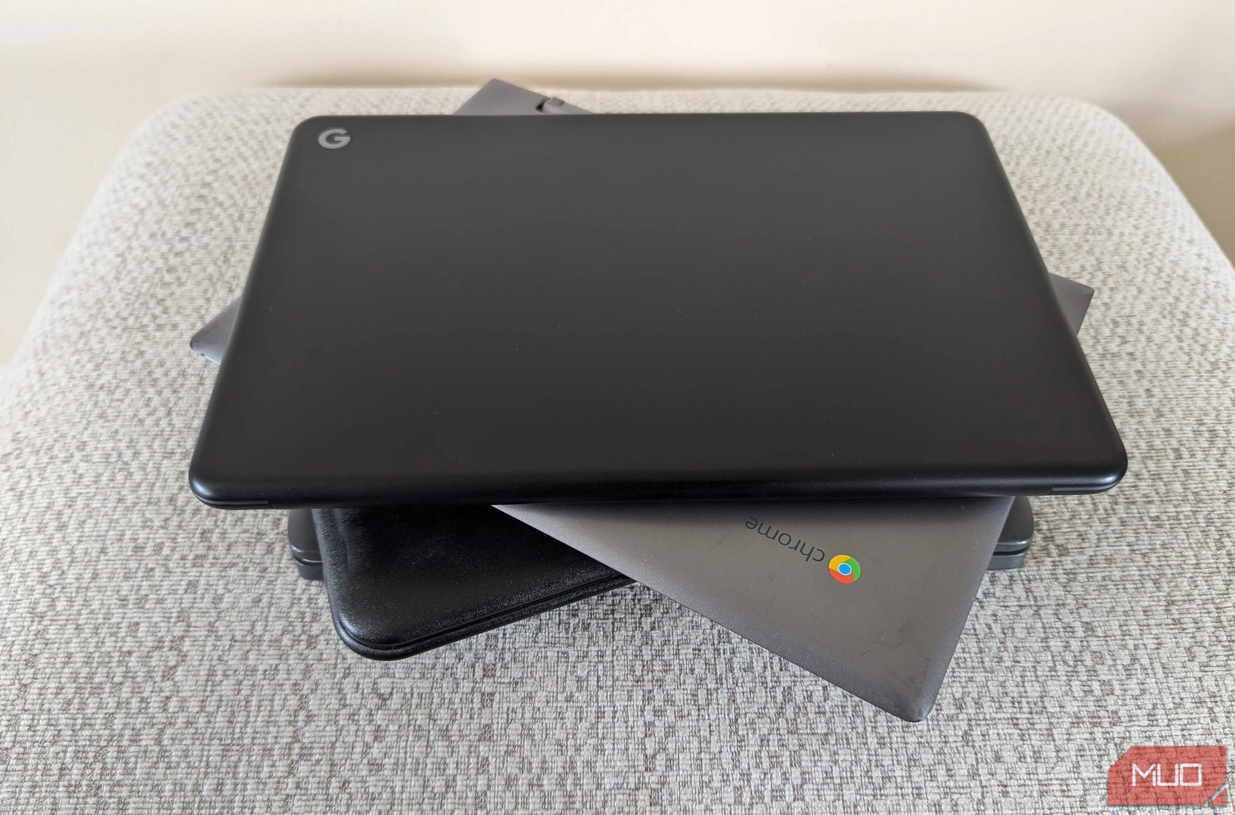 Nhiều chiếc Chromebook nhỏ gọn được xếp chồng lên nhau trên ghế đẩu, thể hiện tính di động và gọn nhẹ của laptop Chromebook.