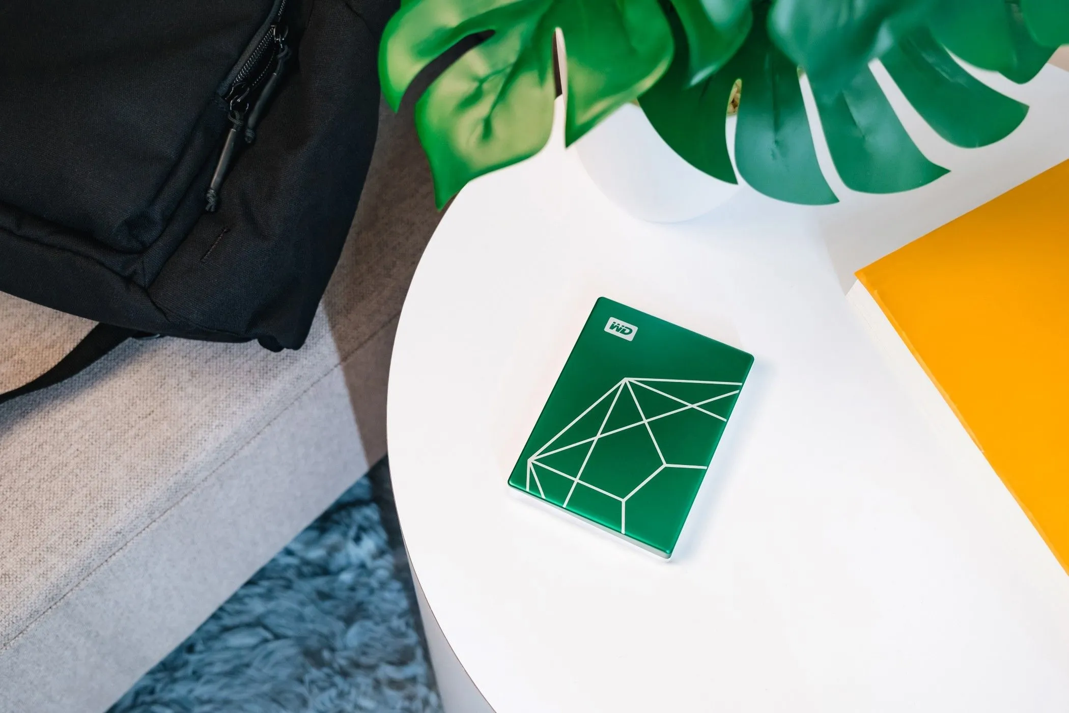 Ổ cứng WD My Passport 20th Anniversary Edition màu xanh ngọc lục bảo đặt trên mặt bàn gỗ