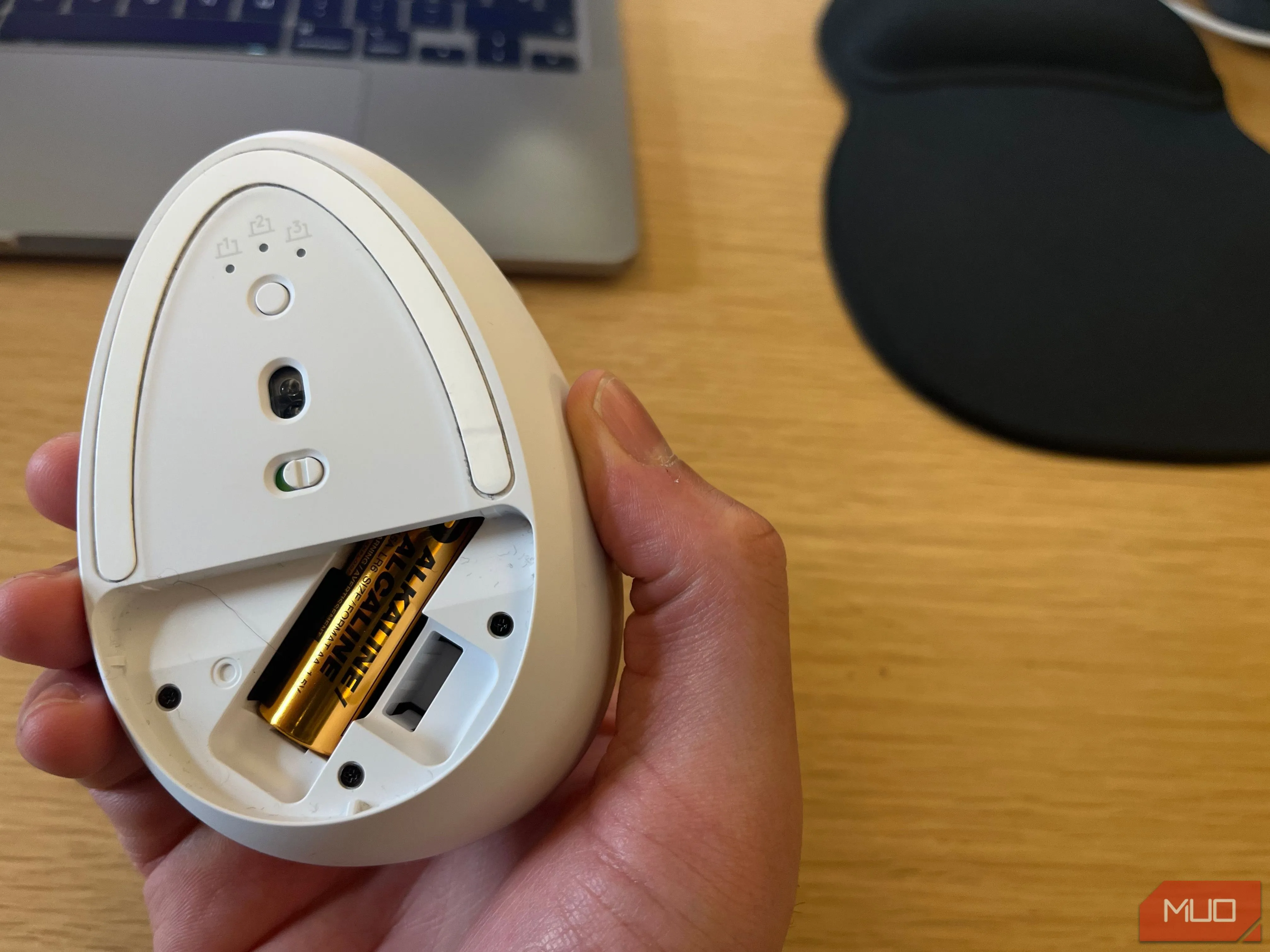 Pin AA đang được lắp vào khoang chứa pin của một chiếc chuột không dây