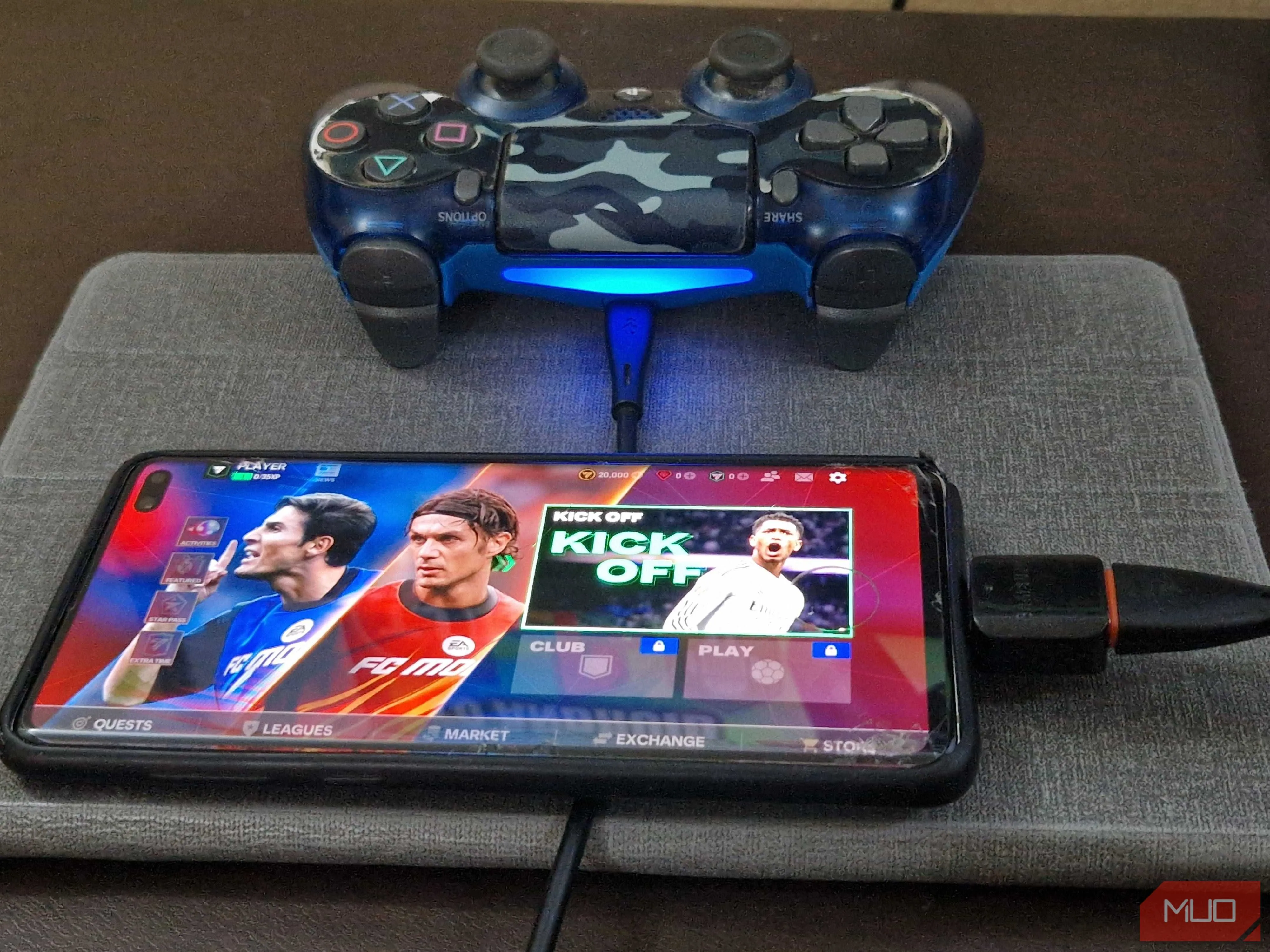 Tay cầm chơi game PS4 được kết nối với điện thoại thông minh qua bộ chuyển đổi OTG và cáp USB