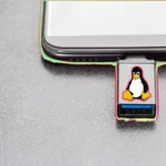 USB cứu hộ SystemRescue với biểu tượng Linux Tux đang cắm vào laptop