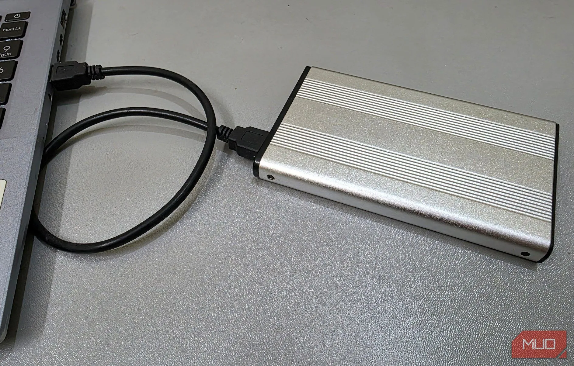 Vỏ bọc ổ cứng gắn ngoài được kết nối với laptop, minh họa việc tạo kho lưu trữ an toàn cho các tài liệu cá nhân và nhạy cảm.